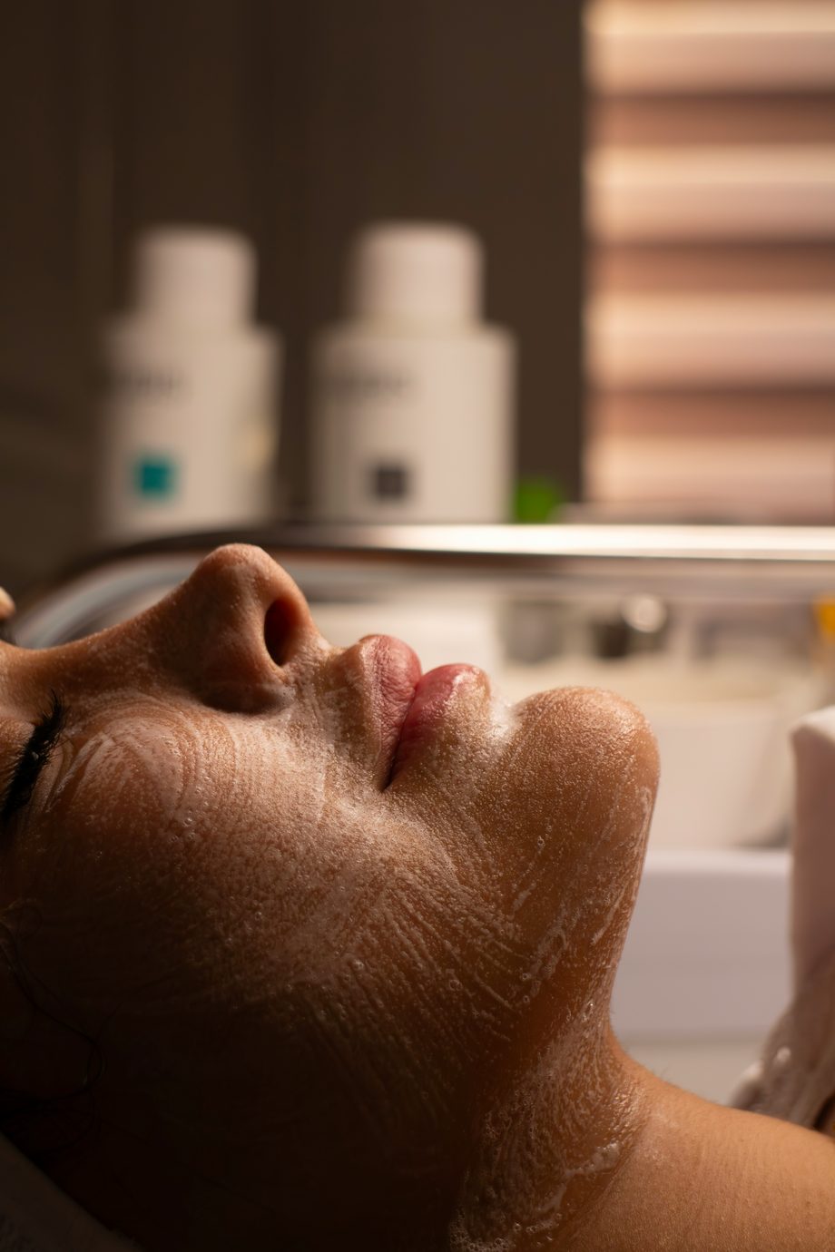 Calm spa treatment room where a woman receives a facial